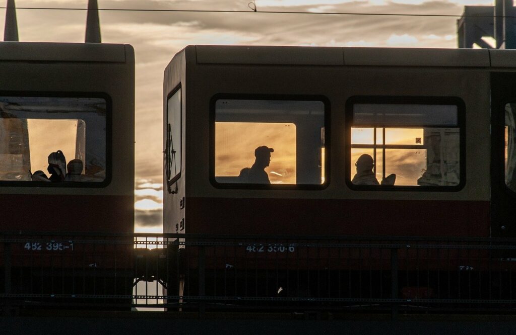 Menschen in einem Zug-Wagen im Sonnenuntergang.